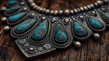 Intricate silver necklace adorned with turquoise stones displayed on rustic wooden surface photo