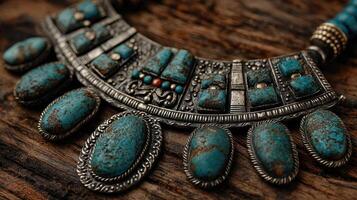 Intricate turquoise necklace displayed on a rustic wooden surface showcasing unique design details and age wear photo