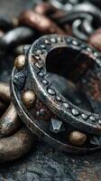 Intricate metal chain and ring with decorative elements on a textured surface in close-up view photo