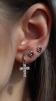 Elegant jewelry featuring sparkling cross and stud earrings worn by a model in a close-up showcase of fashion accessories photo