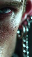 Close-up of human skin with moisture and visible texture, revealing expressive eye and unique earring details in dramatic lighting photo