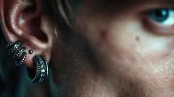 Close-up view of a person's ear showcasing unique earrings and piercing details in a dimly lit setting photo