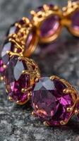 Exquisite gold and purple gemstone bracelet captured on a textured surface in daylight photo