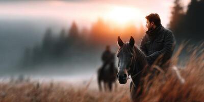 Horseback riders enjoy a serene sunset in a misty landscape with gentle hills in the background during early evening photo