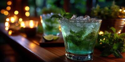 Colorful mojito cocktails garnished with mint leaves on a wooden table illuminated by soft fairy lights at an outdoor gathering during the evening photo