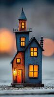 Brightly lit model house stands against a blurred evening background, showcasing intricate design and glowing windows photo