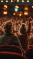 Parent and child enjoying a performance at a theater with excited audience in the background photo
