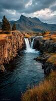 Majestic waterfall cascading through rocky terrain with mountains in the background at sunset photo