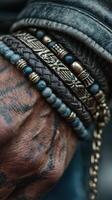 Hand adorned with various bracelets and intricate tattoos showcases a blend of personal style and cultural significance in a close-up view photo
