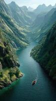 Majestic river flowing through a lush valley with a sailing boat at dawn in a remote mountain landscape photo