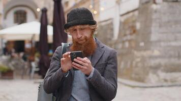 Man using smartphone typing text messages looking for a way on map in mobile navigator app video