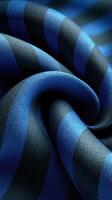 Textile showcasing vibrant blue and black stripes, gently textured and swirling together in elegant folds photo