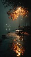 Misty night by the river with a lamp illuminating a bench and reflections on the water photo
