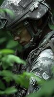 Soldier in tactical gear focusing intently while navigating through dense green foliage during a training exercise photo