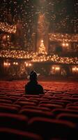 Audience member enjoys a show in a beautifully lit theater during the holiday season with festive decorations and warm lights photo