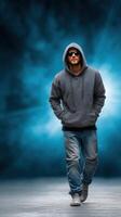 Young man walks confidently in casual attire against a vibrant blue background during twilight hours photo