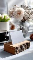 Elegant table setup with blank card holder, flowers, and coffee cup in a cozy atmosphere photo