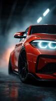 Red sports car gleaming under dramatic lighting in warehouse setting during nighttime photo