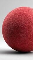 Textured red sphere positioned on a light surface creating a simple yet striking visual contrast photo