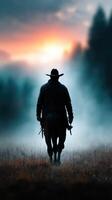 Cowboy rides into sunset with misty mountains in the background during evening light photo