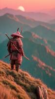 Warrior stands on mountain ridge at sunset, gazing over distant peaks in serene landscape photo
