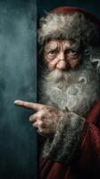 Traditional Santa Claus gestures towards something mysterious while hiding behind a blue wall in a cozy setting during winter photo