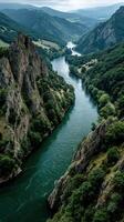 Breathtaking view of a winding river flanked by rocky cliffs and lush greenery in a serene landscape photo