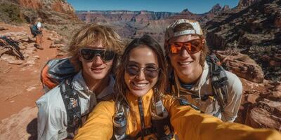 Three friends smiling during a hiking trip in the Grand Canyon on a sunny day with stunning rock formations in the background photo