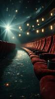 Rows of empty red theater seats illuminated by a spotlight in a quiet cinema atmosphere during a late-night screening photo
