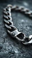 Close-up view of a metallic chain link with intricate details and contrasting textures on a dark surface photo