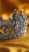 Intricate silver crown adorned with crystals displayed on a soft golden background photo
