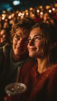 Young couple enjoying a concert together with lights glowing in the background during a lively evening event photo