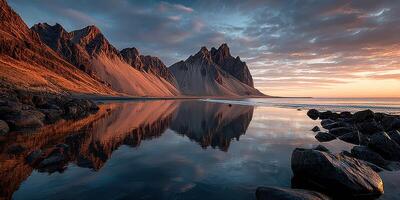 Majestic mountains reflect in calm waters at sunset in a serene coastal landscape photo