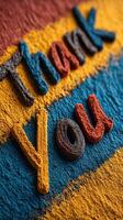 Colorful thank you message created with vibrant powder on a textured background in a creative workspace setting photo