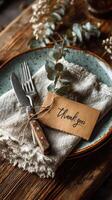 Cozy dining setup with a thank you card on a rustic table featuring cutlery and natural elements photo