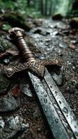 Ancient sword resting on a wet stone path in a dense forest after a light rain during the early morning hours photo