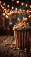 Popcorn bucket rests on a wooden table surrounded by warm, inviting lights at a festive gathering photo