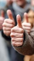 Group of people giving thumbs up in a city setting during daytime, expressing positivity and enthusiasm photo