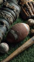 Vintage sports equipment displayed on artificial grass, featuring a football, baseball, and bats in a nostalgic arrangement photo