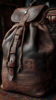 Handcrafted brown leather backpack with intricate designs on display in a cozy workshop setting photo