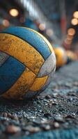 Volleyball rests on a court floor with blurred balls in the background during a sports event photo