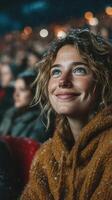 Smiling woman with blue eyes enjoying a snowy outdoor event in a crowded venue at night photo