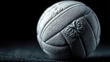 Unique textured gray ball resting on dark surface, showcasing intricate design details in low-light setting photo