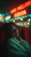 Young person resting in a cozy setting with urban lights illuminating the background at night photo