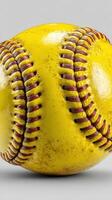 Bright yellow softball showcasing its textured surface and detailed stitching in a neutral background setting photo