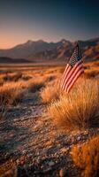 American flag standing proudly in a serene desert landscape during sunset in the mountains photo