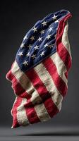 Old American flag draped gracefully against a dark background with intricate textures and color details photo