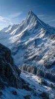 Snow-covered mountain peak stands tall under clear sky in winter landscape, showcasing nature's beauty at sunrise photo