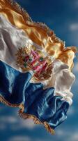Flag of a state flutters under a blue sky with gentle clouds during daytime hours photo
