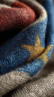 Woven fabric depicting a colorful star pattern in red, blue, and yellow with intricate textile details captured in natural light photo